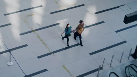 Young couple holding hands walking through airport terminal Video stock 334565674