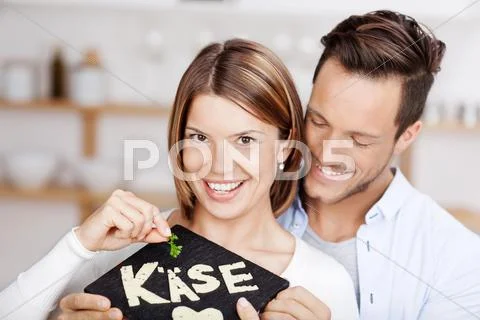 Young couple holding a stone slab with cheese Stock Photos