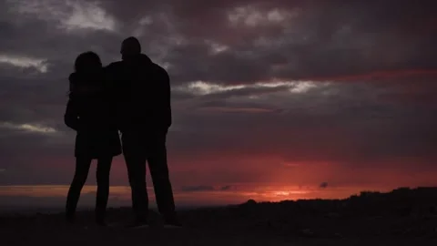 Young couple hugging and looking at sunset view together Video stock 149392893