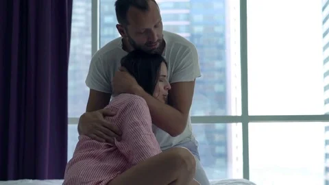 Young couple hugging and making up after fight in bedroom at home Stock Footage 72426167