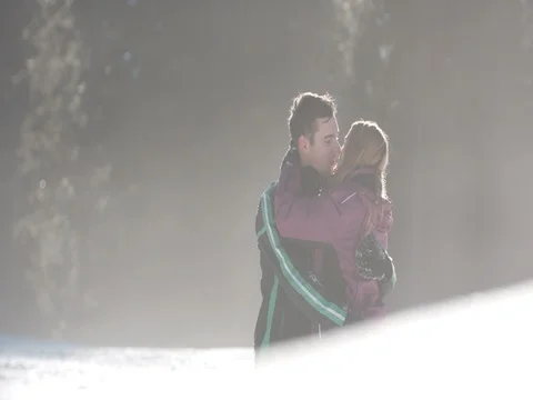 Young couple hugging and sharing a kiss on a beautiful snowy day Vídeo Stock 85073568