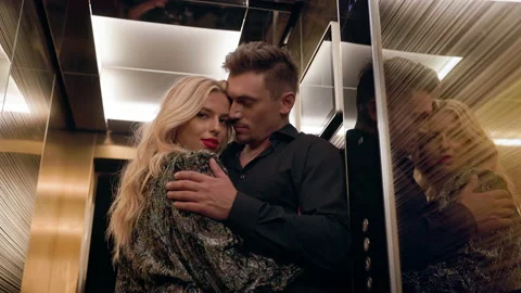 Young Couple Hugging In Elevator. Man With Beard Looks Passionately At Girl. Stock Footage 161116887