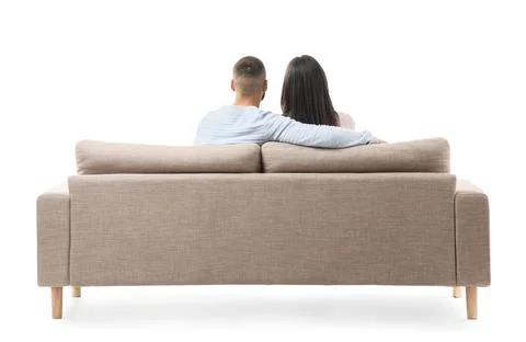 Young couple hugging on grey sofa against white background, back view Stockfoto's