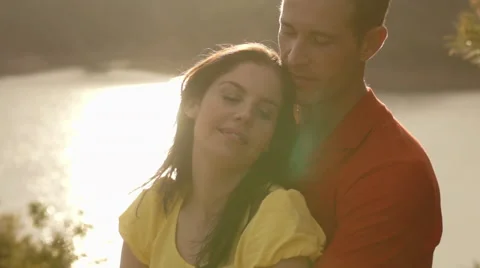 Young couple hugging in sunset overlooking lake. Stock Footage 43667286