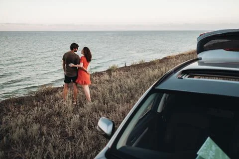 Young Couple Hugging While Standing on the Background of the Sea, Man and Woman 스톡 사진