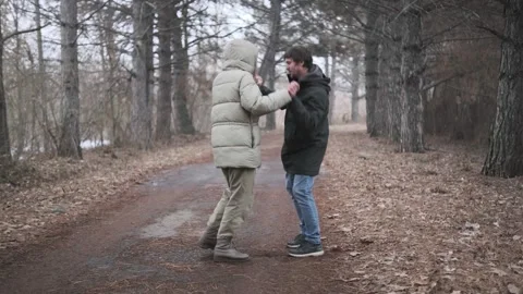 Young couple humorously dancing together in park outdoors, warmly dressed, Vídeos de archivo 336737815