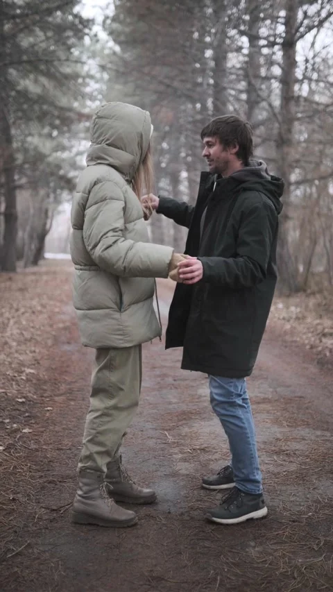 Young couple humorously dancing together in park outdoors, warmly dressed, Vídeos de archivo 336737882