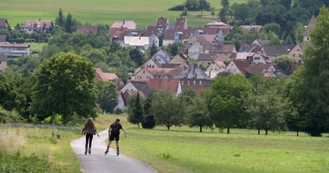 Young couple inline skating at  bicycle path along the Main river, Germany Stock Footage 118922997
