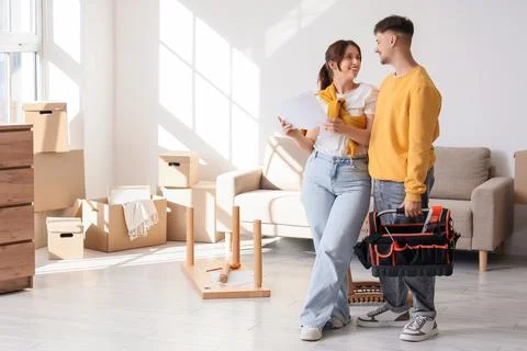 Young couple with instructions and tool bag assembling furniture at home Stock Photos