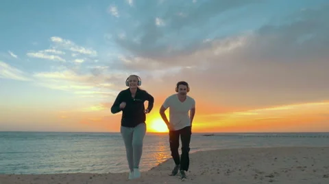 Young Couple Jogging on the Beach Stock Footage 52058385
