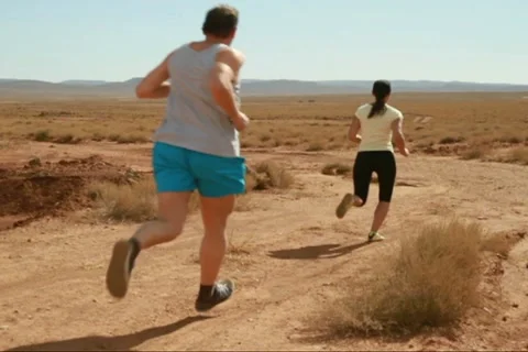 Young couple jogging on desert track, slow motion 스톡 동영상 10834665