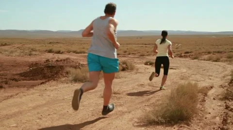 Young couple jogging on desert track, slow motion 스톡 동영상 10834666