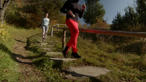 Young couple jogging down the stairs in autumn. Two people. Low angle view Stock Footage 166154411