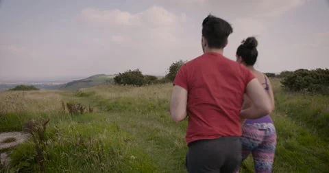 Young couple jogging in field Stock-Footage 59899970