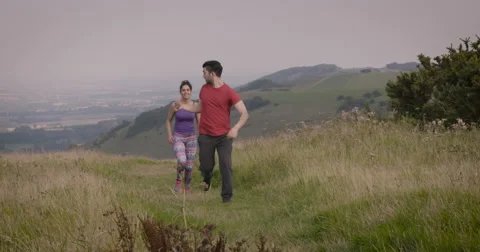 Young couple jogging in field Stock Footage 59899976