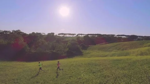 Young couple jogging in the middle of the fields at sunset Vídeo Stock 76316492