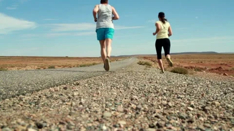 Young couple jogging on the road, slow motion, dolly shot Stockbeeldmateriaal 10834677