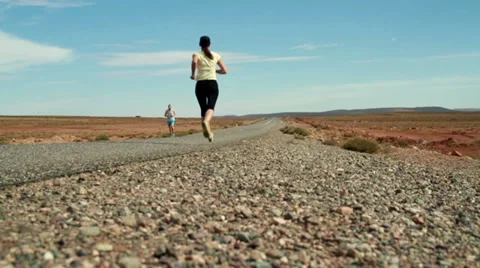Young couple jogging on the road, slow motion, dolly shot Vídeos de archivo 10842364