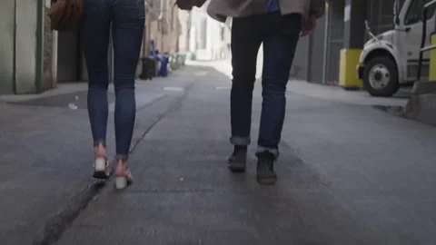 Young Couple Joyfully Walk Through an Alleyway Hand in Hand Vídeo Stock 208718755