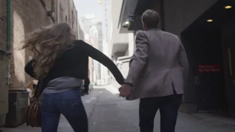 Young Couple Joyously Walk Through an Alleyway Together Vídeo Stock 208718631