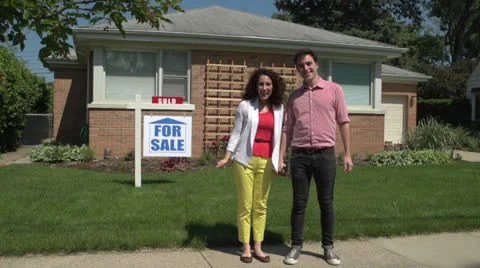 Young couple jumping outside a sold home. Stock Footage 24756481
