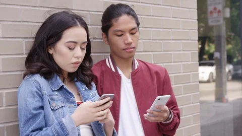 Young couple killing time looking at their smartphones.  - Slow Motion - shot on Stock Footage 125215930