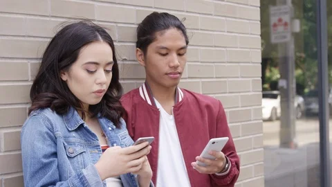 Young couple killing time looking at their smartphones.  - Slow Motion - shot on Stock Footage 125216055