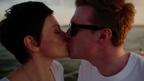 A young couple kisses while walking on a yacht Stock Footage 201191696