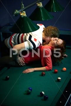 Young couple kissing on pool table Stock Photos