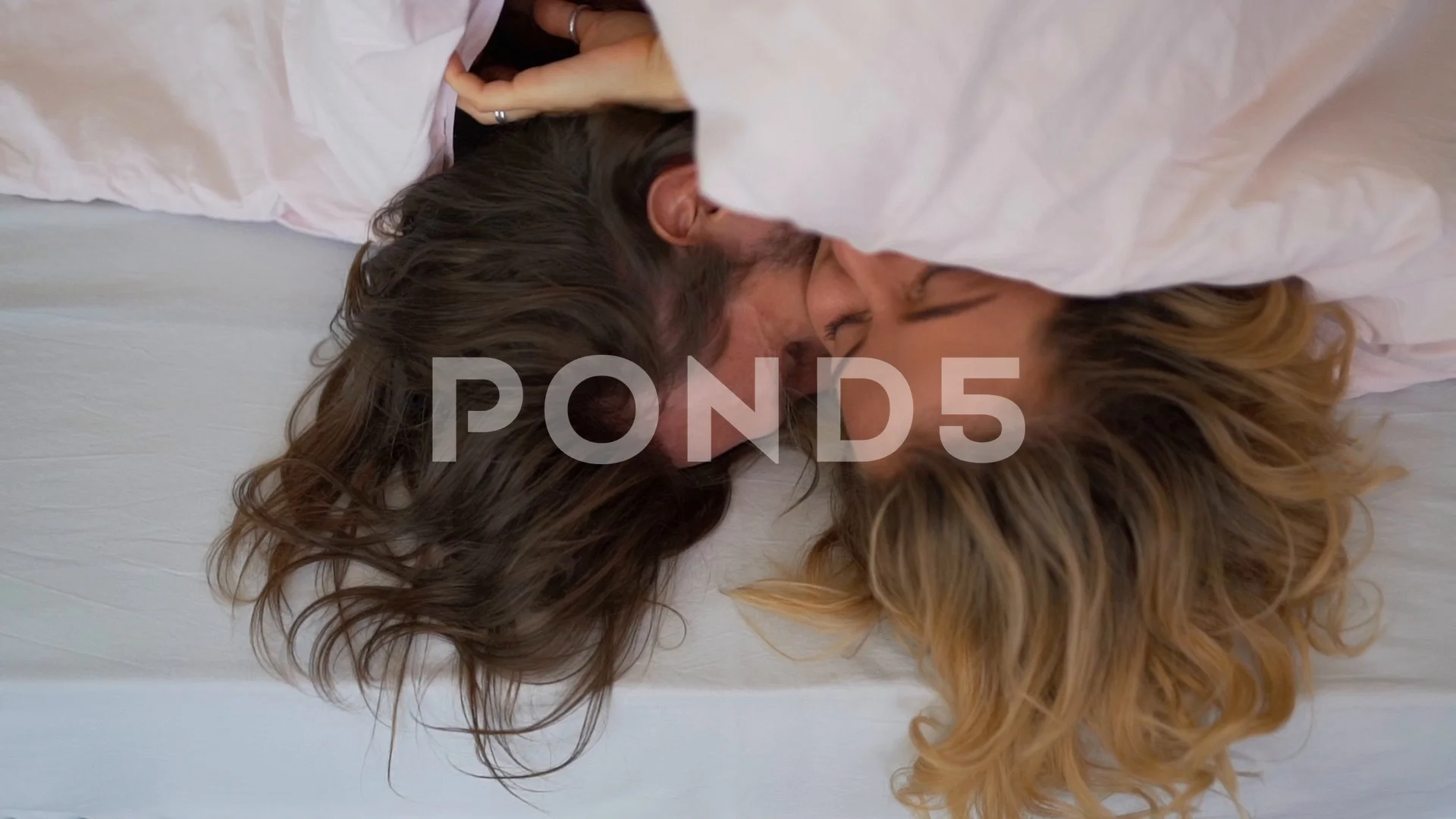 young couple kissing under the covers