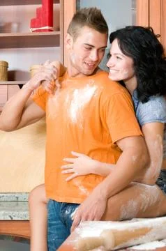 Young couple in the kitchen having fun with flour Stock Photos