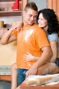 Young couple in the kitchen having fun with flour Stock Photos