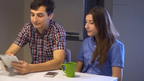 Young couple on the kitchen. Man has internet addiction Stock Footage 100266864