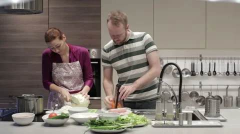 Young couple in the kitchen preparing dinner Stock Footage 62777356