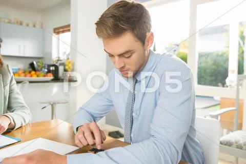 Young Couple At Kitchen Table Calculating Bills And Finance