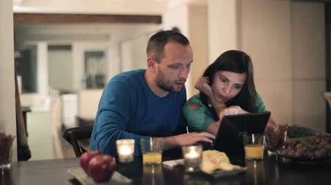 Young couple with laptop sitting by the table at home HD Stock Footage 33777930