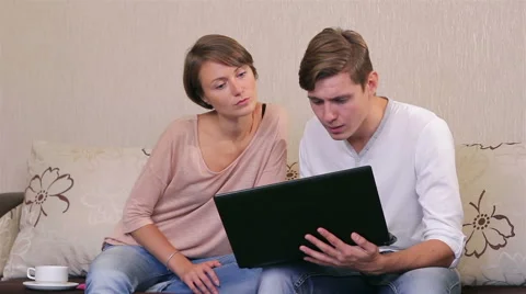 Young couple with a laptop on a sofa Stock Footage 56668528