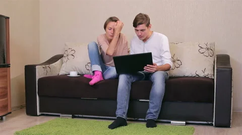 Young couple with a laptop on a sofa Stock Footage 56668586