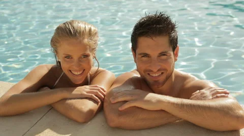 Young couple laughing at side of pool Video stock 43624589