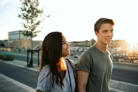 Young couple laughing while walking together in the city Foto stock