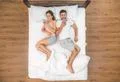 The young couple lay on the bed and phone. View from above Photo