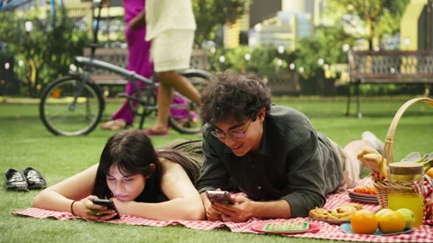 Young couple laying side by side illustrating phubbing and phone addiction Stock Footage 341411527