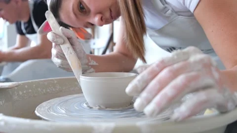 Young couple is learning to work at a potter's wheel Stock-Footage 169572417
