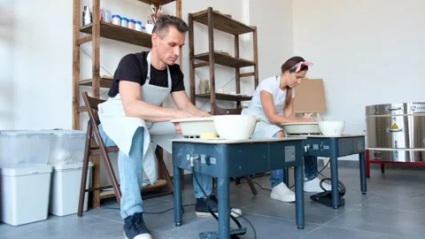 Young couple is learning to work at a potter's wheels Stock-Footage 169643468