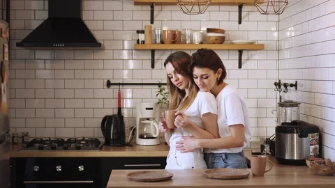 A young couple of lesbians gently cuddle at home. Video stock 125056371
