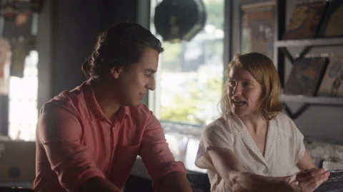 A young couple look through rows of vinyl records in a record store 動画素材 122599200