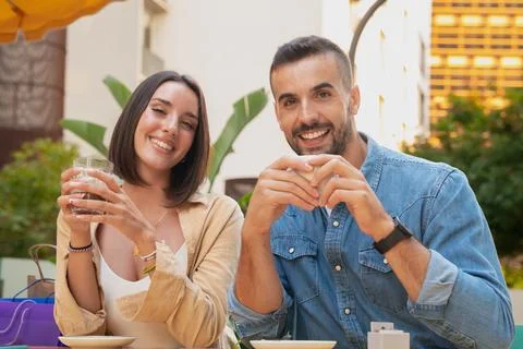 Young couple looking at camera with a coffee and smiling Stock Photos