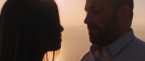 A young couple looking at each other with love at sunset, close up. Stock Footage 136243757