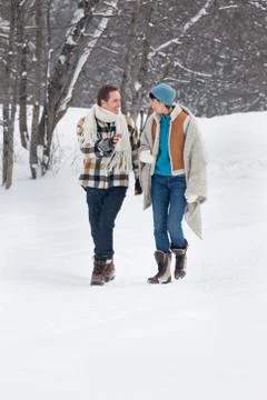 Young couple looking at each other, walking in snow Stock Photos