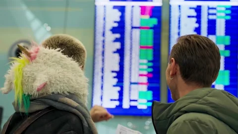 Young couple looking at flight schedule at airport. Pair checking airline Stock Footage 169603725